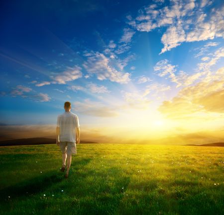 one man and field of spring grass and sunsetの写真素材