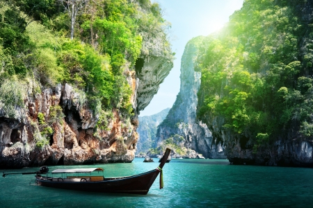 long boat and rocks on railay beach in Krabi, Thailandの写真素材