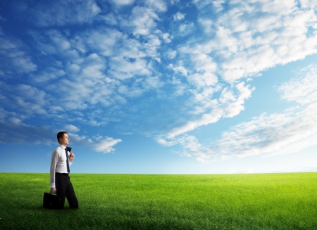 young business man wolking at the field of grassの写真素材