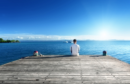 young man relax siting on pier の写真素材