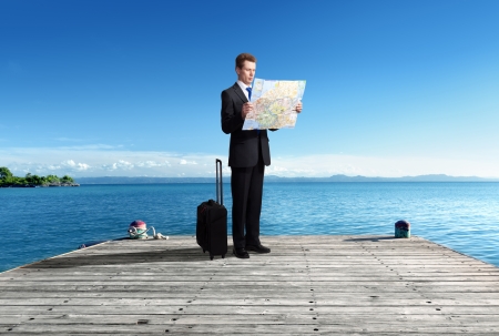 Business man standing on pier with map in handsの写真素材