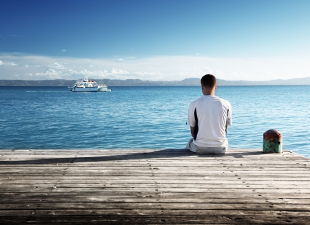 young man relax siting on pier の写真素材