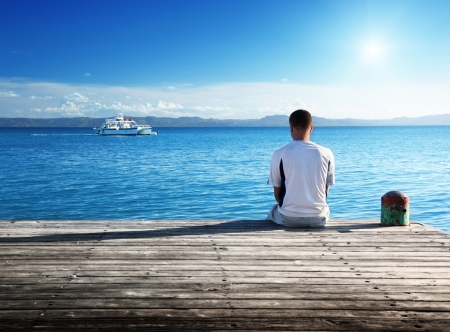 young man relax siting on pier の写真素材