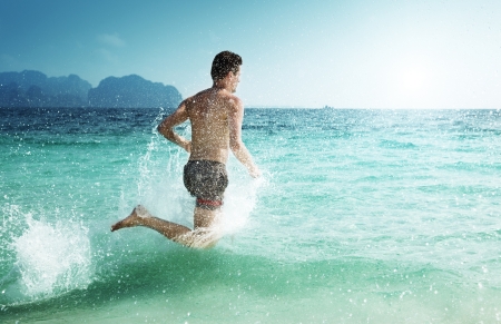 running man in water of tropical seaの写真素材