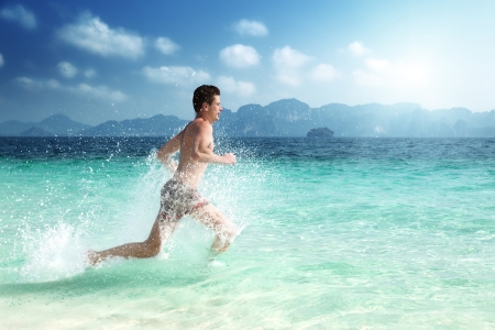 running man in water of tropical seaの写真素材