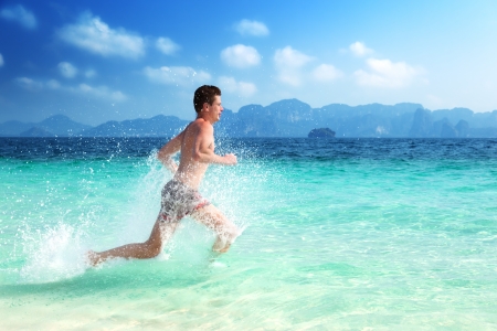 running man in water of tropical seaの写真素材