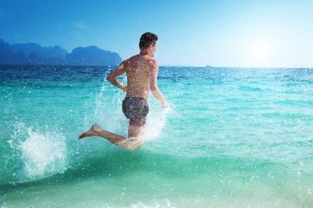 running man in water of tropical seaの写真素材