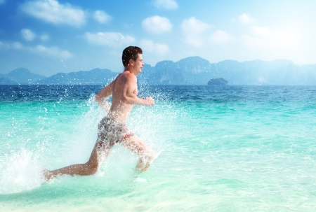 running man in water of tropical seaの写真素材