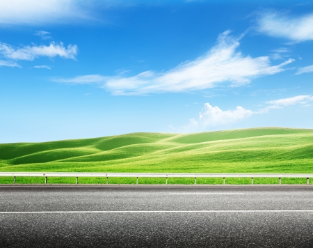 asphalt road and perfect green fieldの写真素材