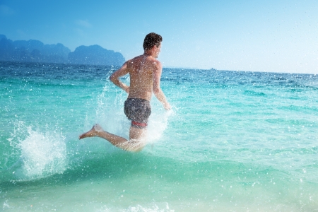 running man in water of tropical seaの写真素材
