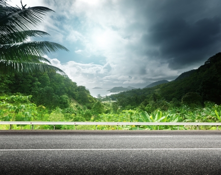 asphalt road and tropical forestの写真素材