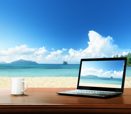 notebook on table and tropical beachの写真素材