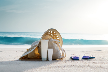 Sun lotion, hat  with bag at the tropical beachの写真素材