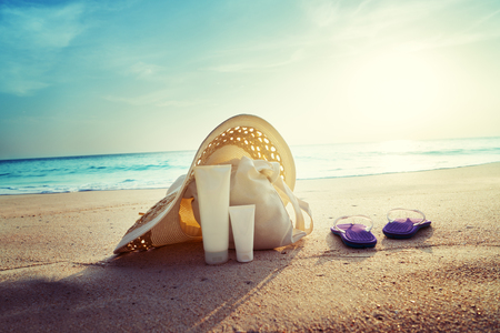 Sun lotion, hat  with bag at the tropical beachの写真素材