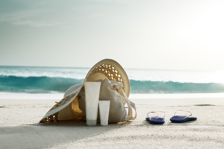 Sun lotion, hat  with bag at the tropical beachの写真素材