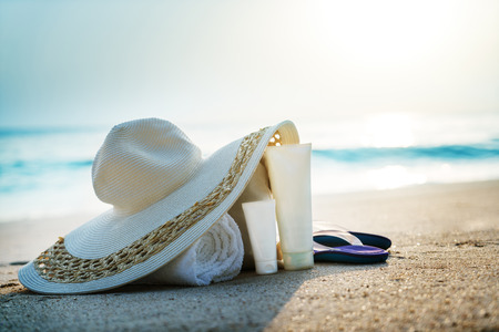 Sun lotion, hat  with bag at the tropical beachの写真素材