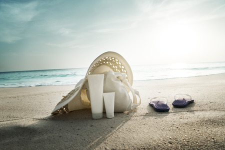 Sun lotion, hat  with bag at the tropical beachの写真素材