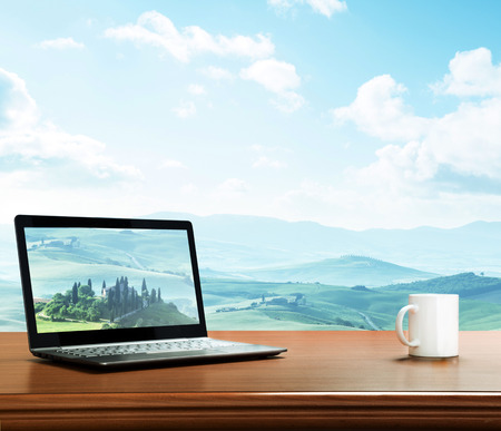 notebook and cup on table, tuscany, Italy as backgroundの写真素材
