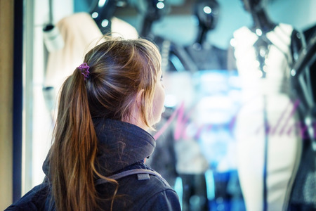 girl looking in the showcase on the night city street