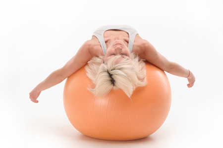 healthy athletic girl resting on a fit ball after gymnastics. isolated on white backgroundの写真素材