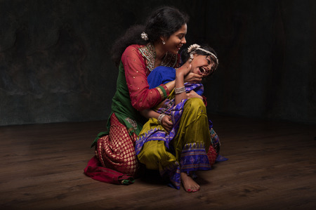 very happy Indian family , mom plays with her daughter. dressed in national costumesの写真素材