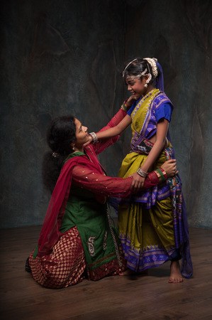 happy Indian family , mother instills daughter of folk cultureの写真素材