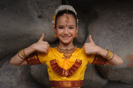 Im ready to go to dance. beautiful girl dressed in festive costume. shows thumbs up his big fingersの写真素材