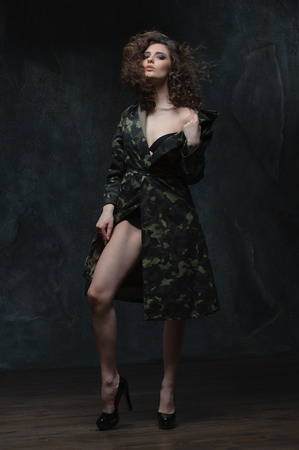 beautiful girl in a military cloak. curly brunette in lingerieの写真素材