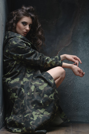 woman in uniform caught in an impasse. Sitting in a dark corner and waiting for helpの写真素材