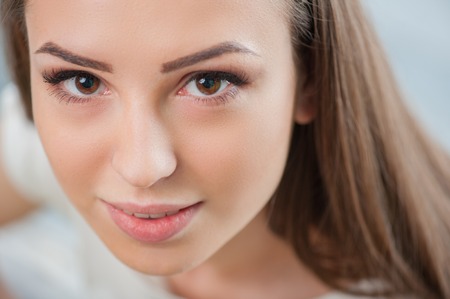 Close up portrait of beautiful brunette girl is very interested in doing somethingの写真素材