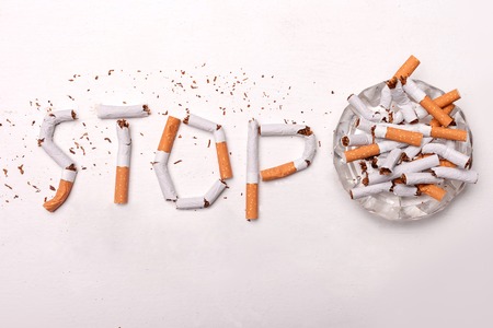Stop smoking. Close up of broken cigarettes on ash-tray. Isolatedの写真素材