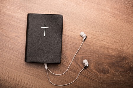 Close up of a Bible connected with earphonesの写真素材