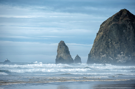 Beautiful Cannon Beach near Haystack Rock in Oregon with cloudy skyの写真素材