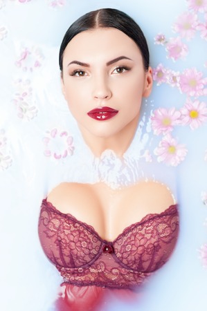 This is my way to relax. Attractive young woman is taking a bathtub with pleasure. She is lying and relaxingの写真素材