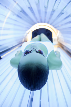 Just relax and get some pleasure. Attractive woman is sunbathing in solarium.の写真素材