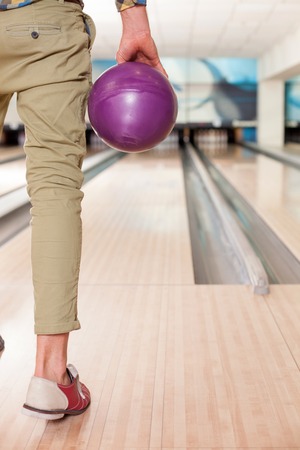 Close up of arm of man ready to throw the bowling ball. He is standing opposite the alleyの写真素材