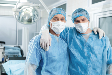 Our surgical team is the best. Portrait of experienced two male surgeons embracing after successful...