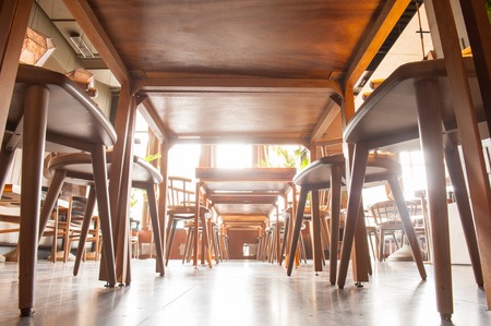 Low angle of restaurant floor under the table near wooden chairsの写真素材