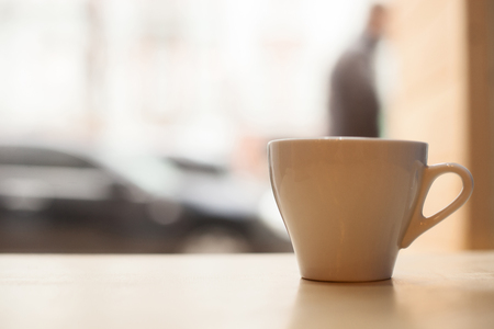 Just drink and relax. Close up of a cup of coffee on table near the window. Copy space in left sideの写真素材