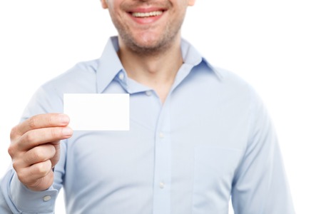 Happy businessman is showing his business card. He is standing and smiling. Focus on paper. Isolatedの写真素材