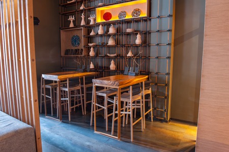 Modern wooden tables with chairs and special decoration create cozy atmosphere in restaurantの写真素材
