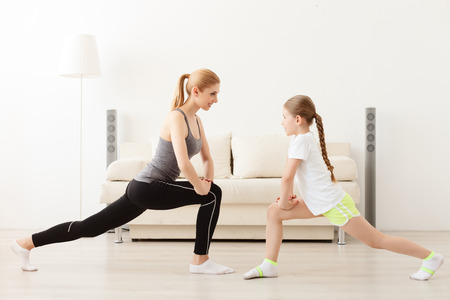 Fitness for the mind and body. Mother and daughter doing yoga exercise and stretchingの写真素材