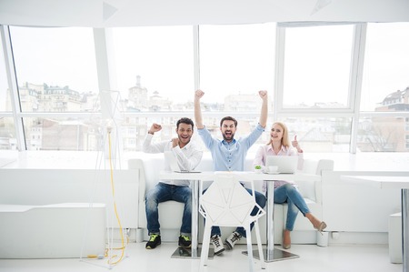 Success is our only goal. Diverse group of positive staff members celebrating together in their...