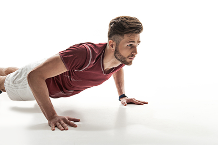 Fit young sportsman is training his body. He is looking forward with aspiration. Isolated and copy space in right sideの写真素材