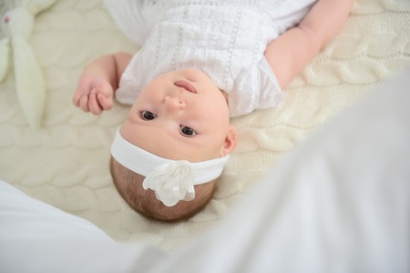 So much to see around me. Cropped shot of adorable baby girl looking up at camera and lying on...