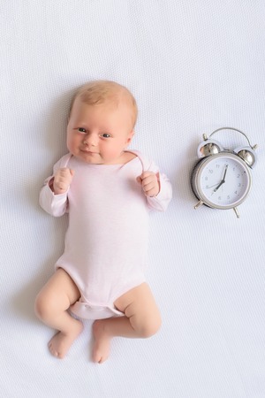 Come have some fun with me. Top view of little baby girl lying on diaper and looking into camera...