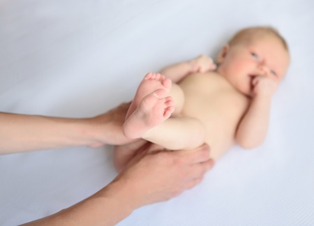 Gymnastics is very useful. Close up photo of mother doing massage and gymnastic for her cute baby...