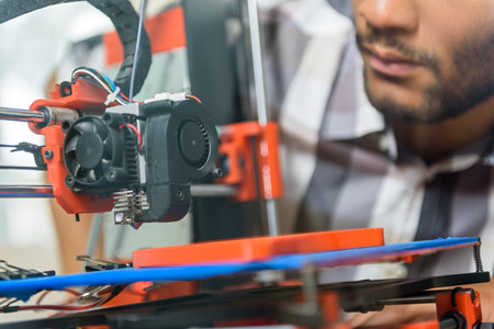 Close up of young man using 3d printer for prototypingの写真素材