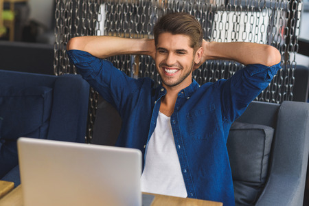 I did it, man sitting in front of laptop with cheerful smile on his faceの写真素材