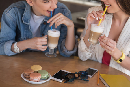 close up of a table with stuff on it while girls drinking latte macchiatoの写真素材